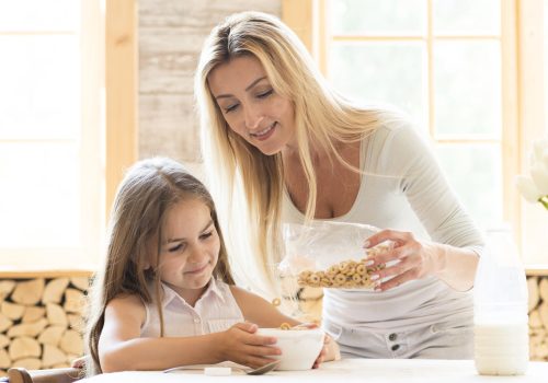mother-giving-cereals-breakfast-daughter (1)